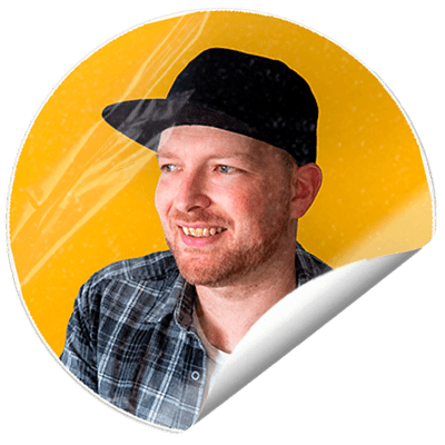 Portrait of freelance graphic designer Adam Hayles smiling against a yellow background