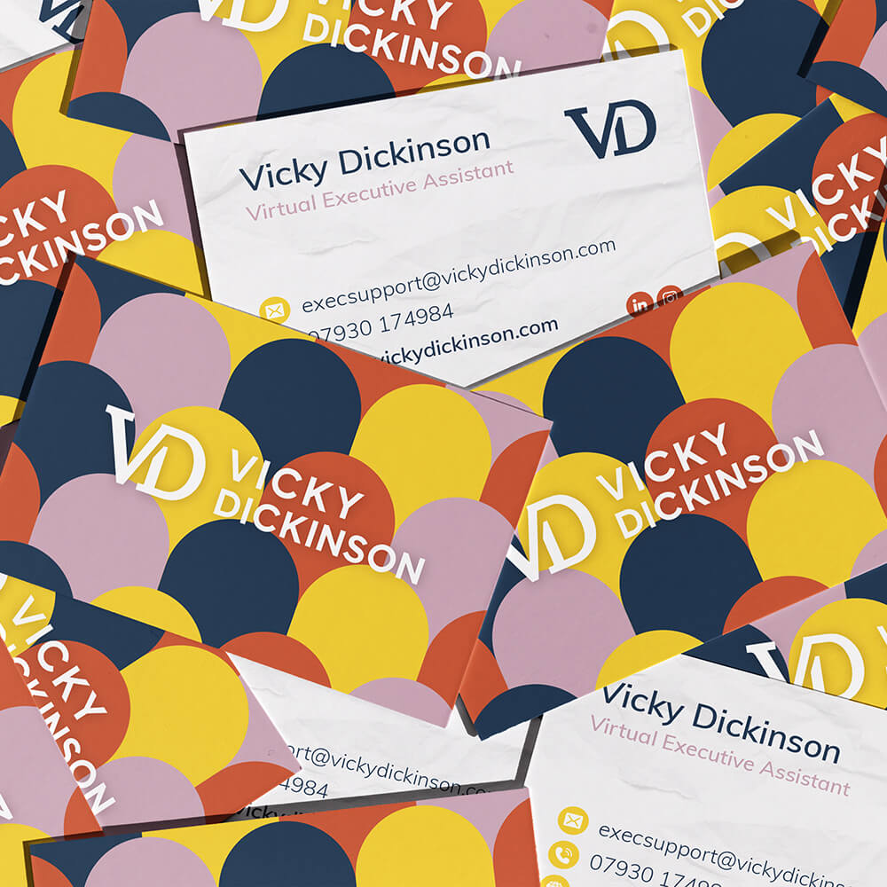 Colourful business card designs scattered across a surface showcasing graphic design and print design services