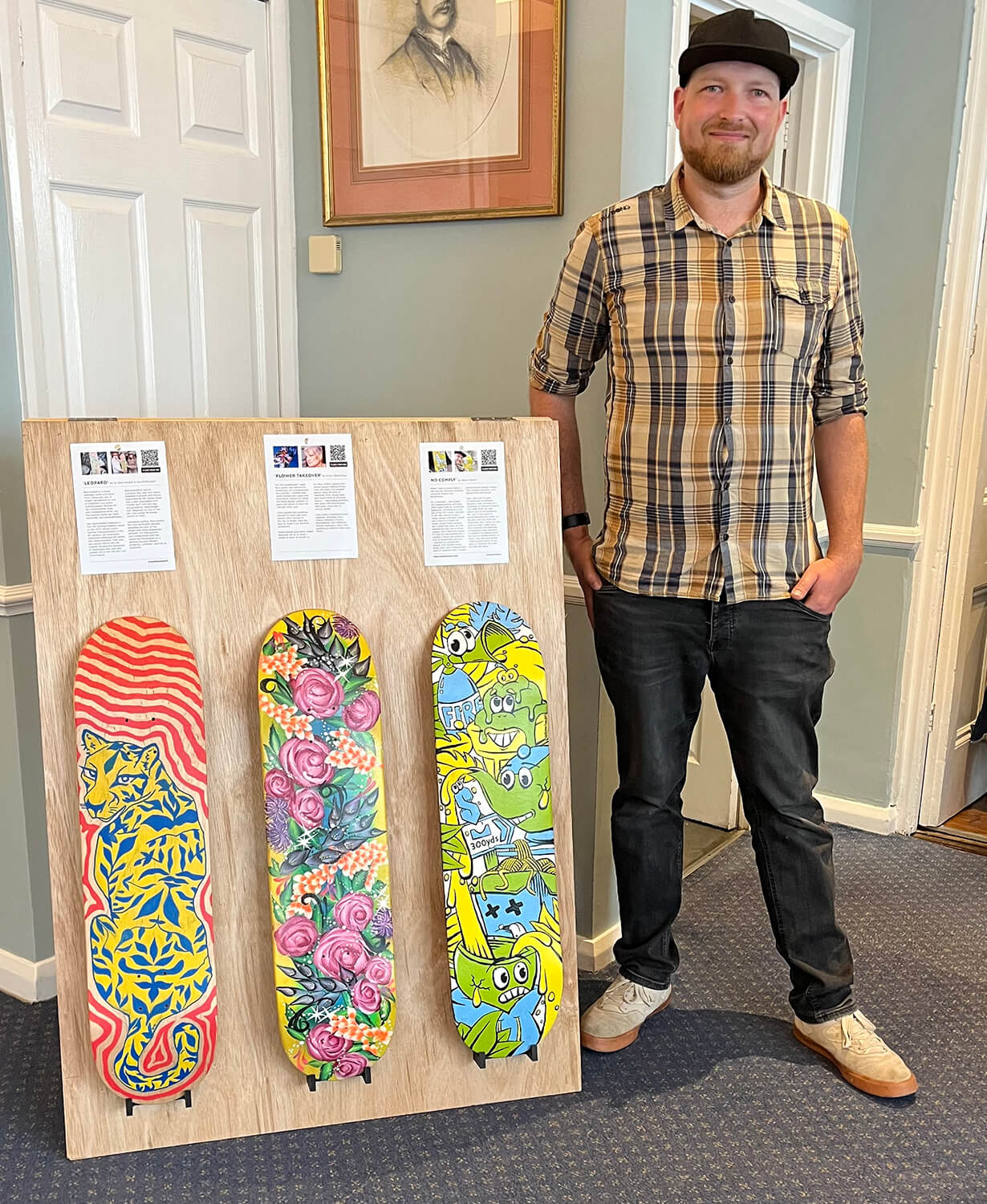 Freelance graphic designer Adam Hayles standing beside skateboards at the Royal Solent Yacht Club in Yarmouth